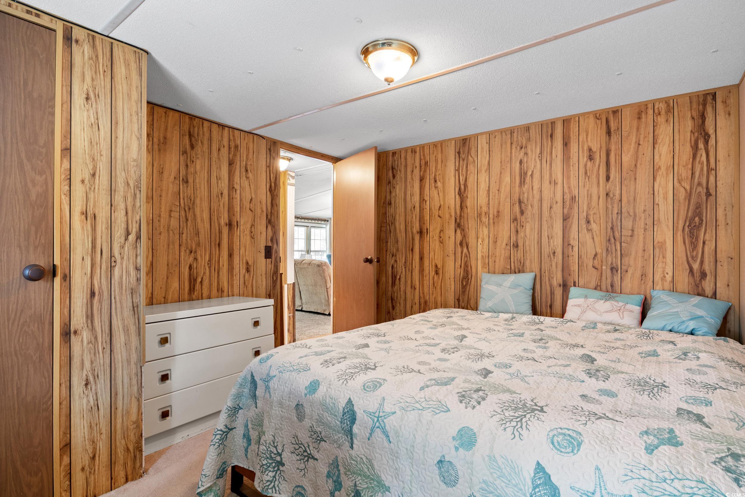 563 Plum Court Myrtle Beach, SC 29579 - Photo 10 of 34 Bedroom featuring wood walls and carpet flooring