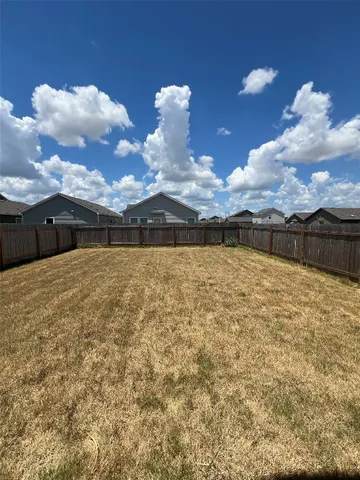 a view of house with yard and lake view in back
