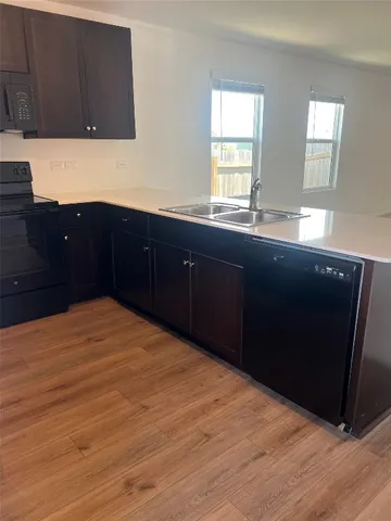 a kitchen with a sink a refrigerator and trees