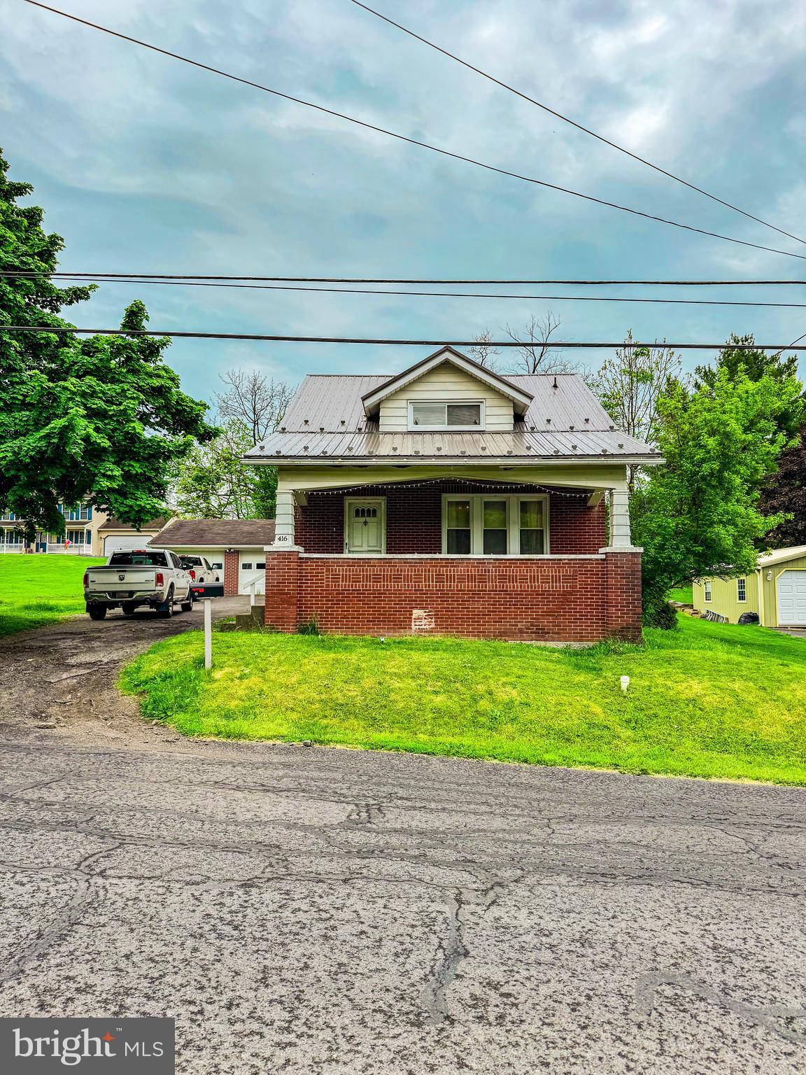 a front view of a house with a garden and trees
