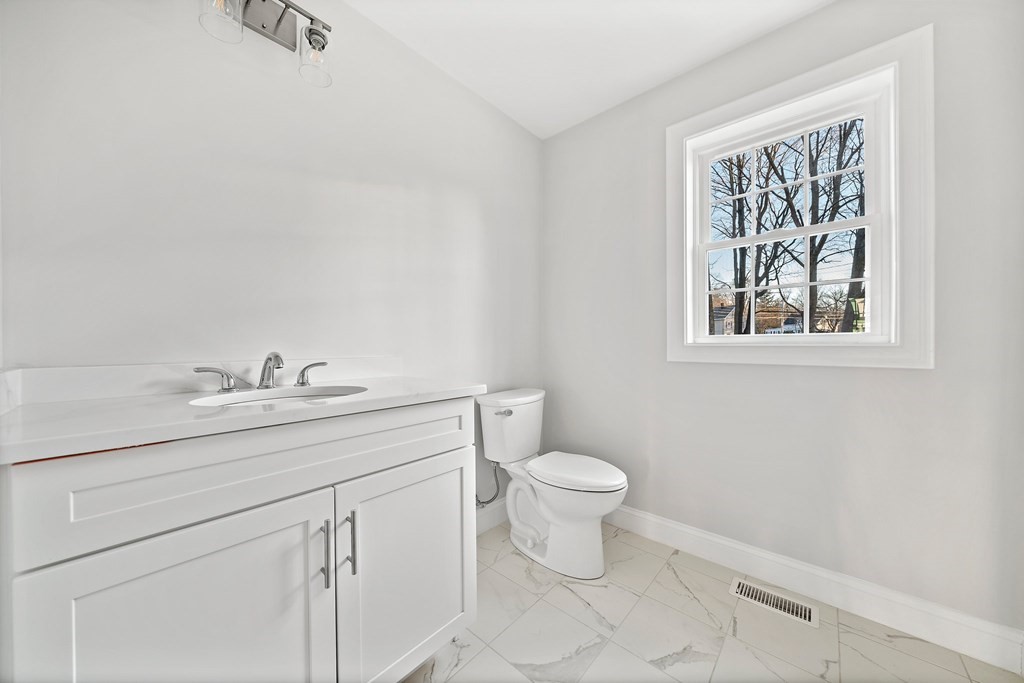 2 Pelissier Circle Randolph, MA 02368 - Photo 23 of 29 a bathroom with a toilet a sink a mirror and a window