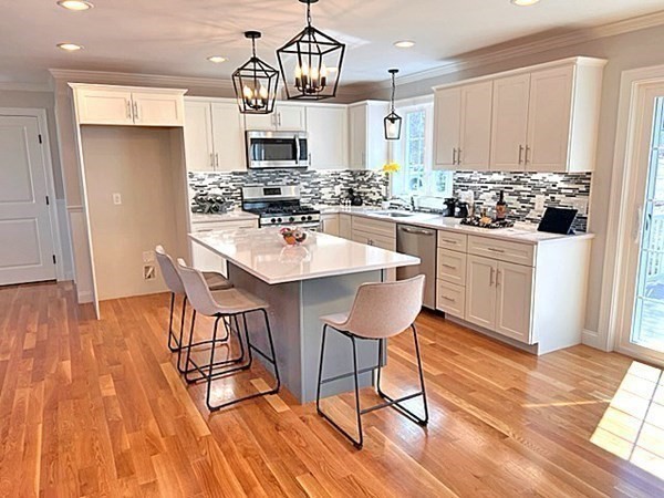 2 Pelissier Circle Randolph, MA 02368 - Photo 8 of 29 a kitchen with stainless steel appliances kitchen island granite countertop a table and chairs in it