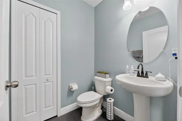 a view of a hallway with bathroom and wooden floor