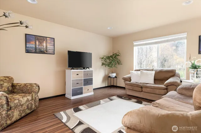 a living room with furniture a flat screen tv and a window