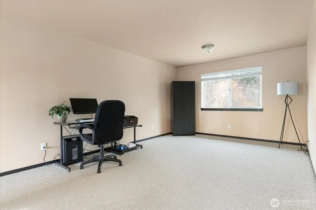 a view of a workspace with furniture and a window