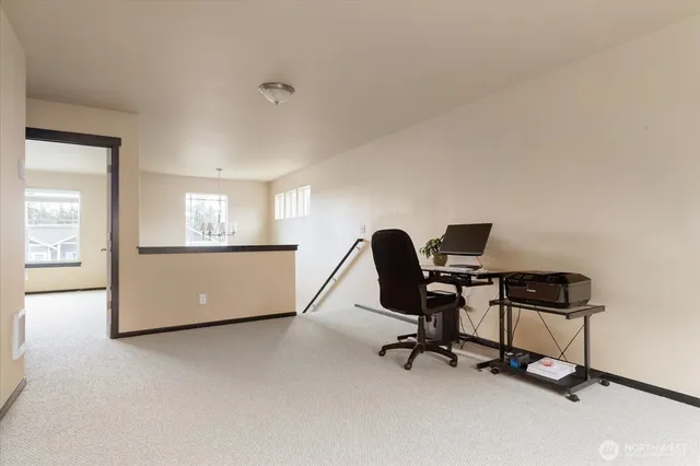 a view of a workspace with furniture and a window
