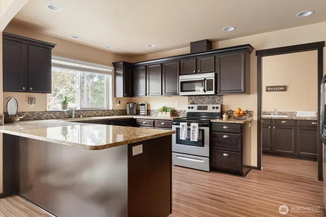a kitchen with stainless steel appliances granite countertop a stove a sink and a refrigerator