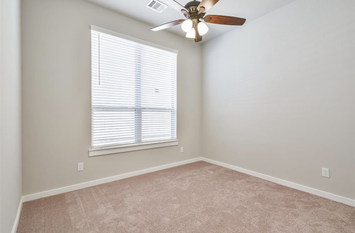 10005 Red Beadtree Place Conroe, TX 77385 - Photo 16 of 29 an empty room with a window and a fan