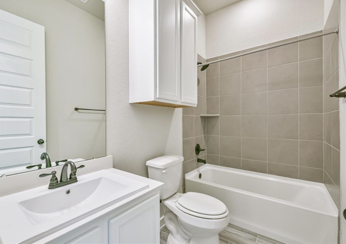 10005 Red Beadtree Place Conroe, TX 77385 - Photo 17 of 29 a bathroom with a sink toilet and shower