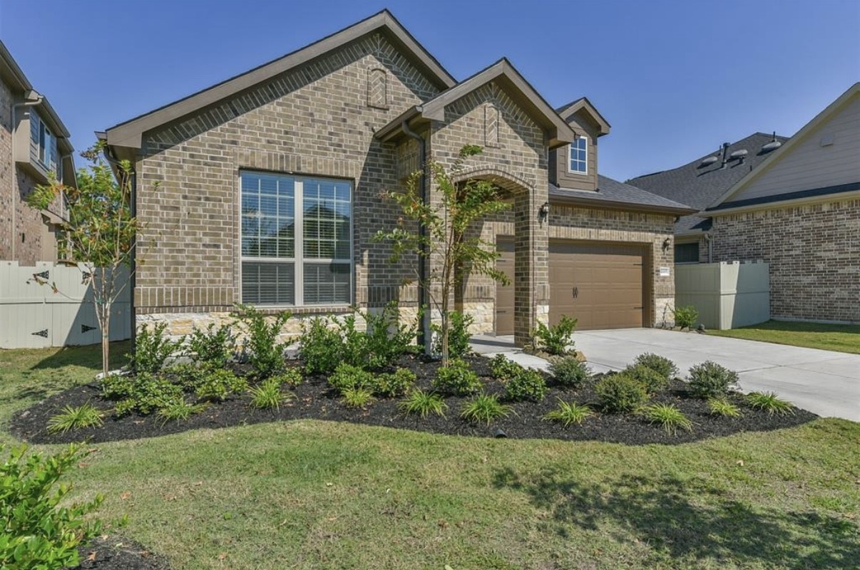 10005 Red Beadtree Place Conroe, TX 77385 - Photo 2 of 29 a front view of a house with garden