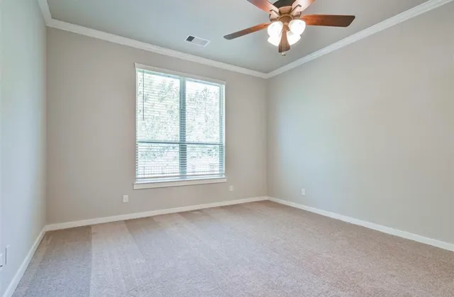 an empty room with a window and a fan
