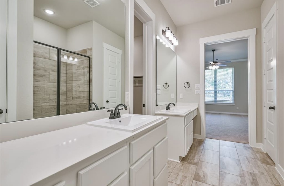 10005 Red Beadtree Place Conroe, TX 77385 - Photo 23 of 29 a spacious bathroom with a double vanity sink mirror and shower