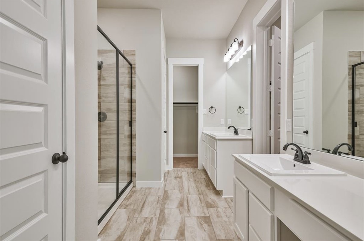 10005 Red Beadtree Place Conroe, TX 77385 - Photo 24 of 29 a bathroom with a double vanity sink a mirror and a shower