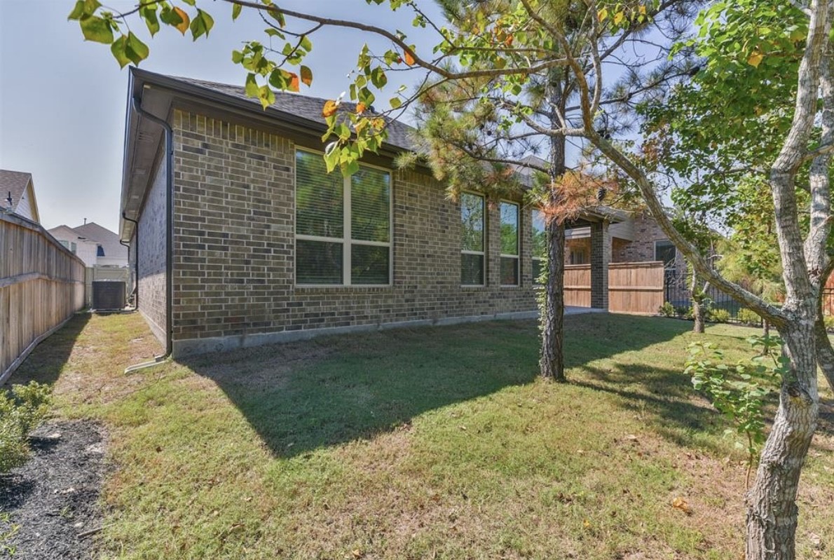 10005 Red Beadtree Place Conroe, TX 77385 - Photo 27 of 29 a front view of a house with a yard and garage