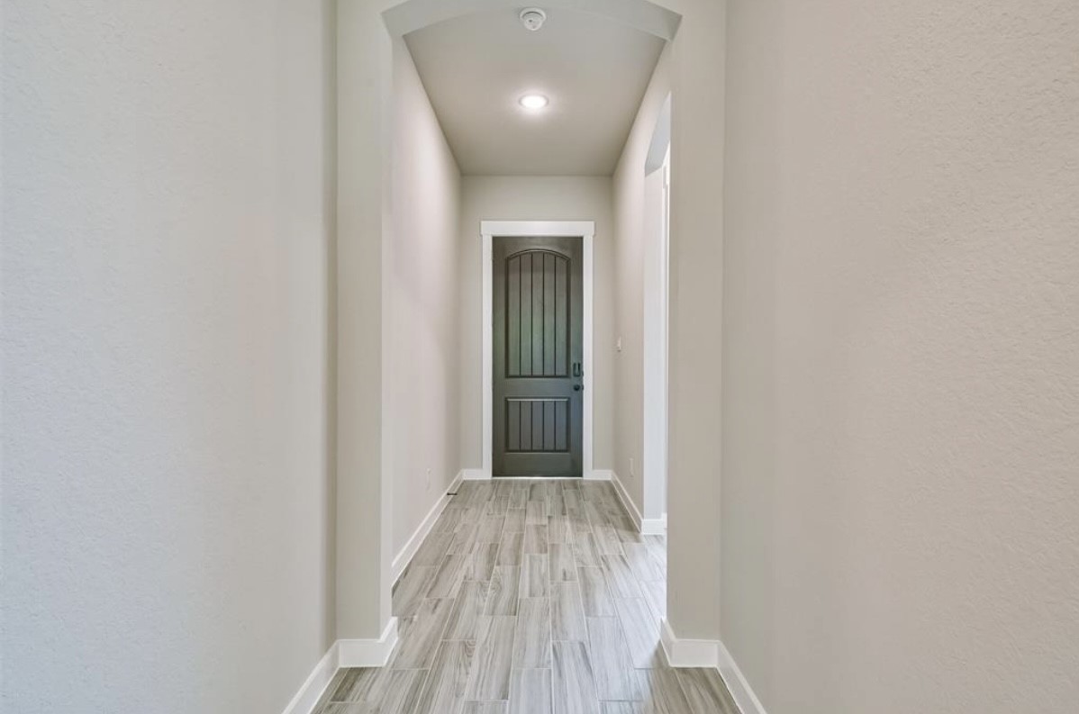 10005 Red Beadtree Place Conroe, TX 77385 - Photo 4 of 29 a view of a hallway with wooden floor