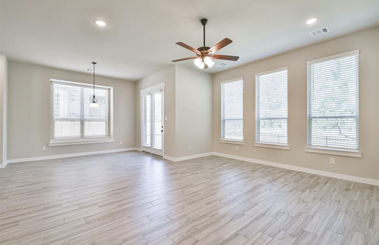 10005 Red Beadtree Place Conroe, TX 77385 - Photo 7 of 29 a view of an empty room with wooden floor and a window