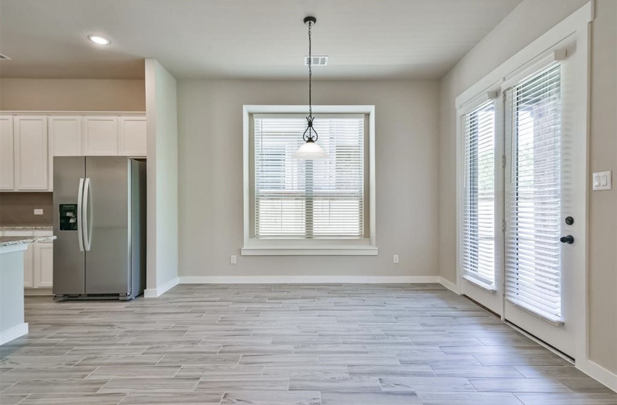 10005 Red Beadtree Place Conroe, TX 77385 - Photo 8 of 29 a view of an empty room with a window and wooden floor