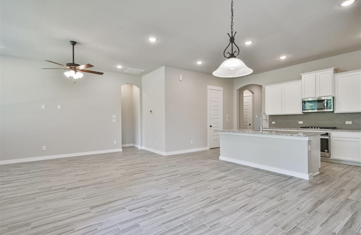 10005 Red Beadtree Place Conroe, TX 77385 - Photo 9 of 29 a view of a kitchen with a sink dishwasher a kitchen counter top space and wooden floor