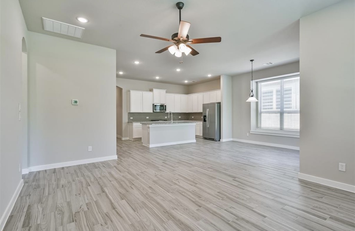 10005 Red Beadtree Place Conroe, TX 77385 - Photo 10 of 29 a view of an empty room with wooden floor and a window
