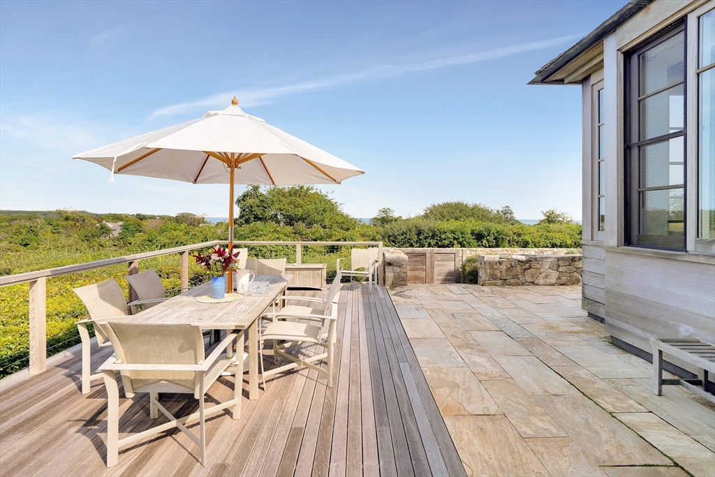 2 Squibnocket Road Chilmark, MA 02535 - Photo 12 of 42 a view of a patio with couches and table under an umbrella