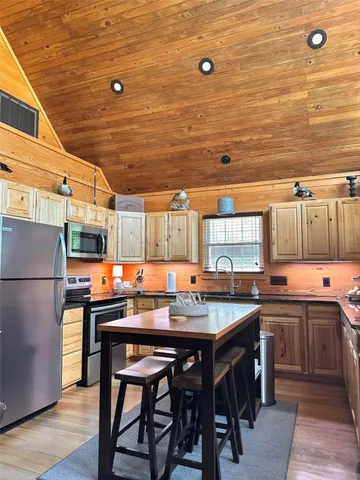 a kitchen with stainless steel appliances a stove a refrigerator and a dining table