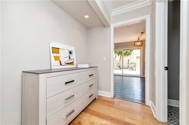 a view of a hallway to a room with wooden floor
