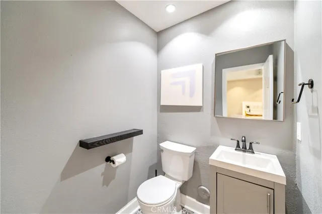 a bathroom with a toilet a sink a mirror and a window