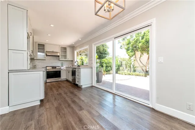 a kitchen with a refrigerator a stove top oven and a large window