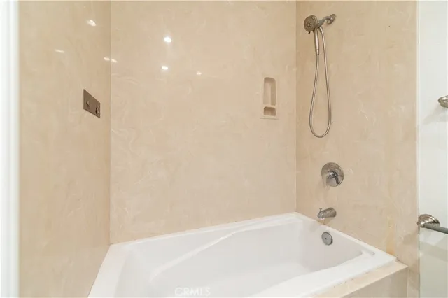 a white bath tub sitting next to a shower