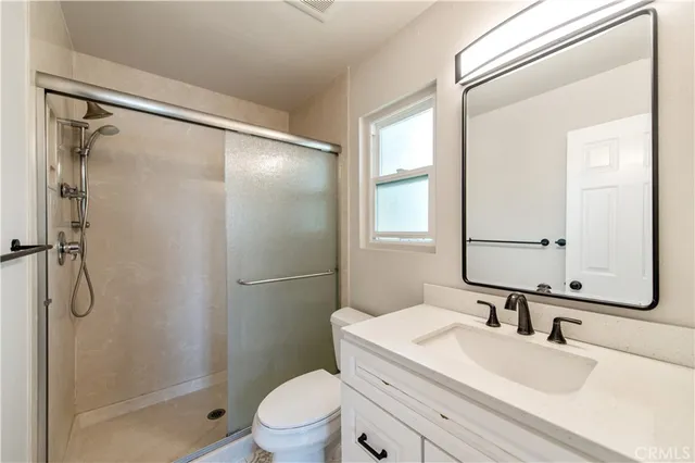 a bathroom with a granite countertop sink toilet and shower