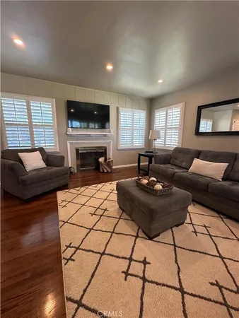 a living room with furniture a flat screen tv and a fireplace