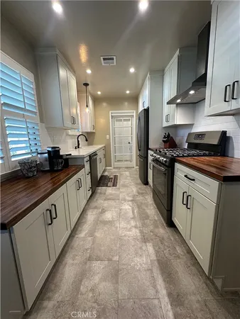 a large kitchen with stainless steel appliances granite countertop a stove a sink dishwasher and a refrigerator