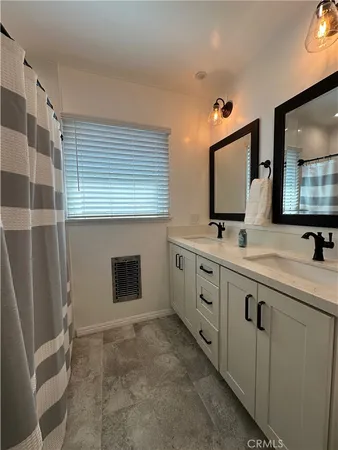 a bathroom with double sink and mirror