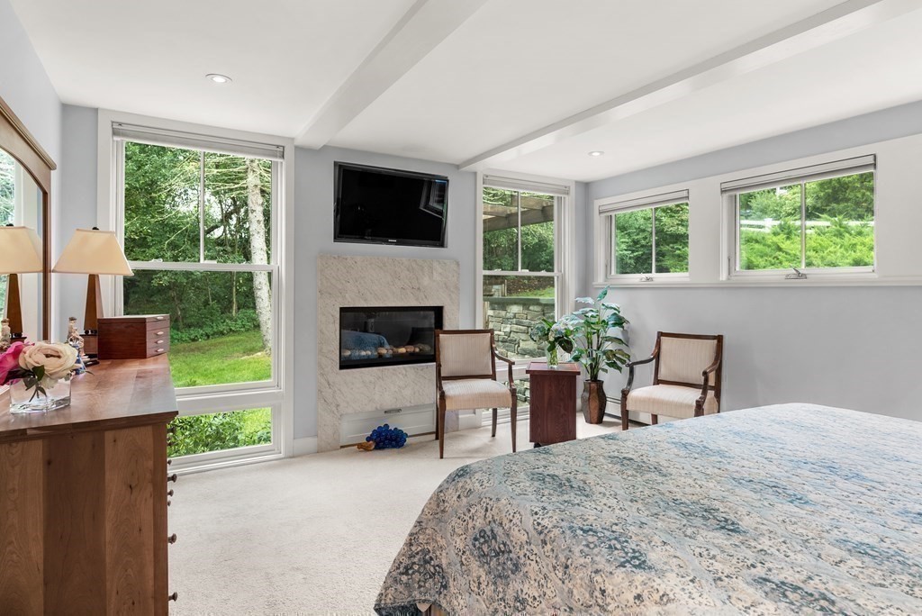 328 Dover Road Westwood, MA 02090 - Photo 17 of 41 a bedroom with a bed a flat screen tv and a fireplace
