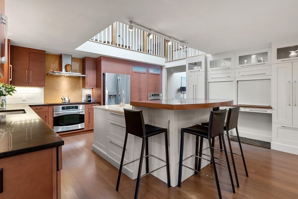 328 Dover Road Westwood, MA 02090 - Photo 6 of 41 a kitchen with a table chairs microwave and cabinets