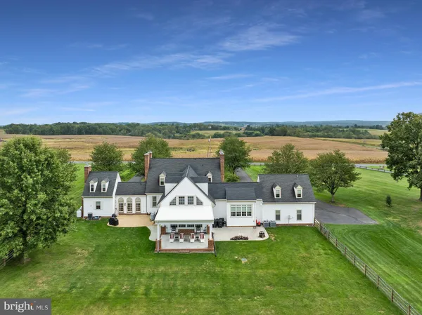 a view of a house with a big yard and large trees