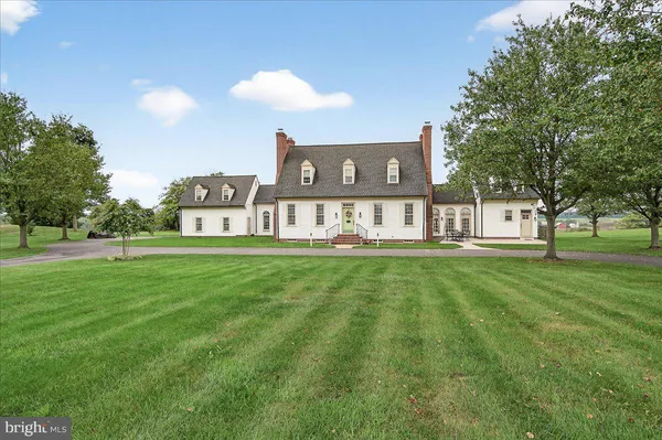 a view of a house with a big yard and large trees