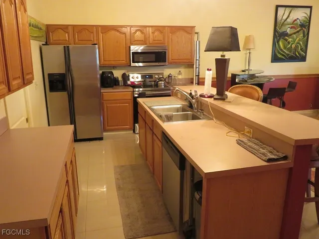 a kitchen with stainless steel appliances a sink a refrigerator a stove and a refrigerator