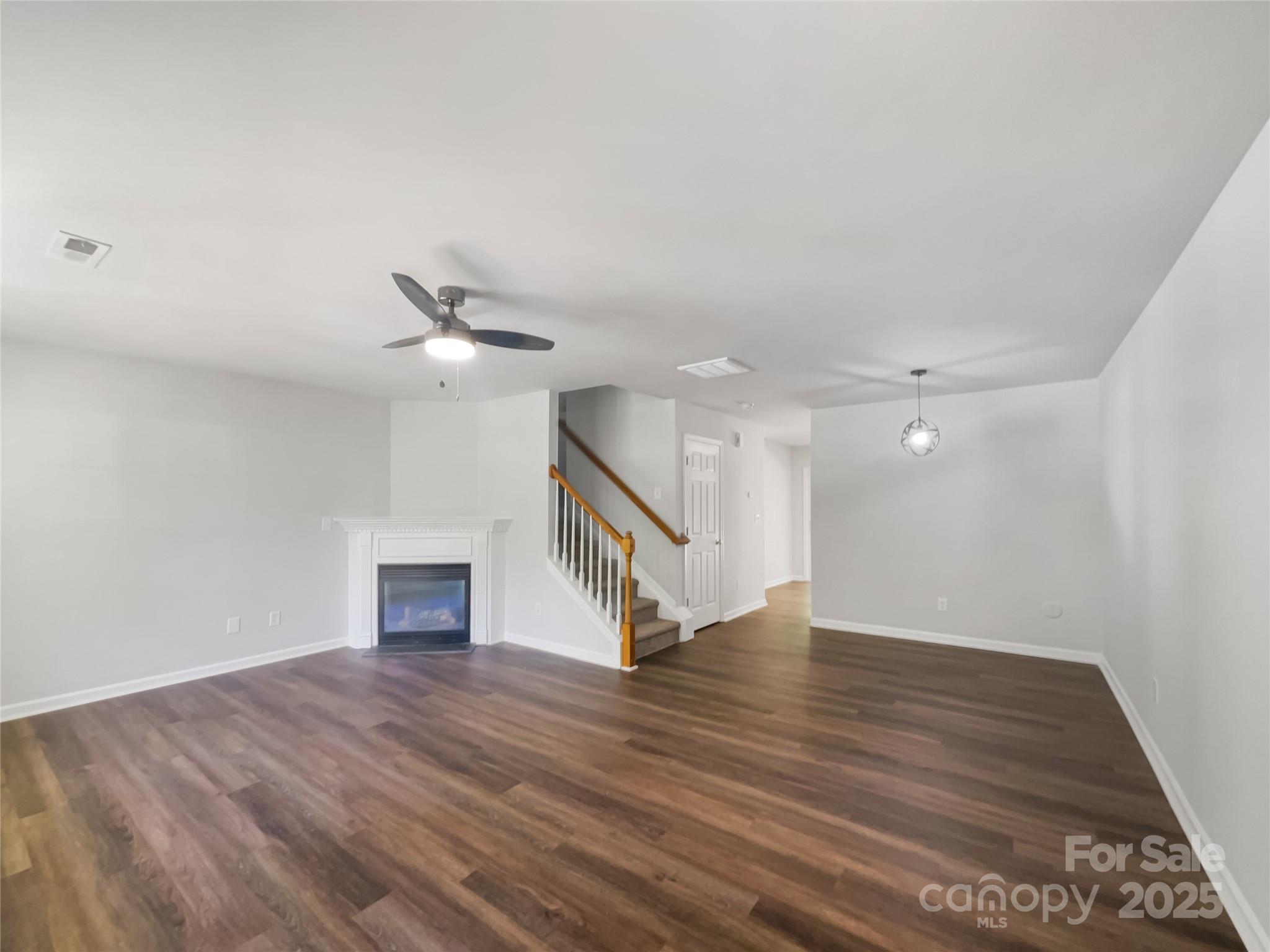 146 Marakery Road, Unit B Mooresville, NC 28115 - Photo 13 of 19 an empty room with wooden floor ceiling fan and windows