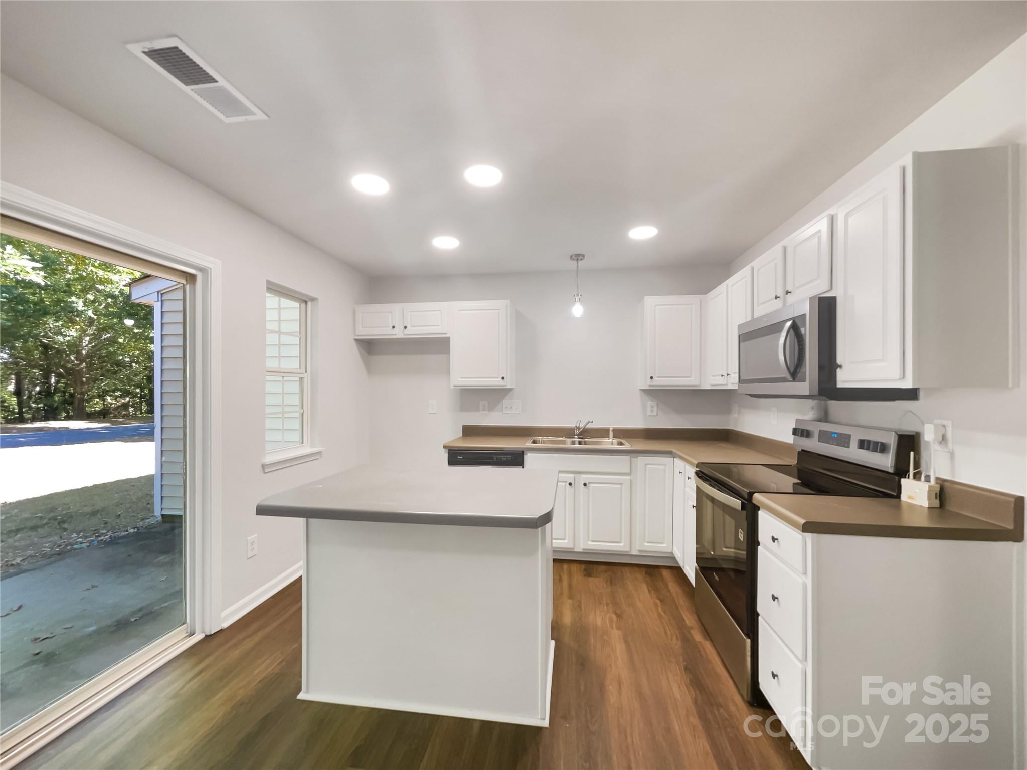 146 Marakery Road, Unit B Mooresville, NC 28115 - Photo 6 of 19 a kitchen with stainless steel appliances granite countertop a stove a sink and a microwave