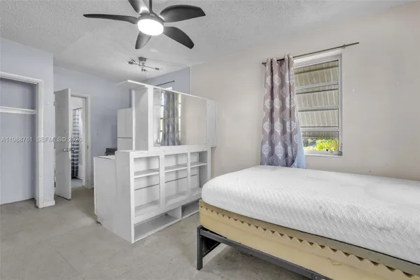 a spacious bedroom with a bed and a window