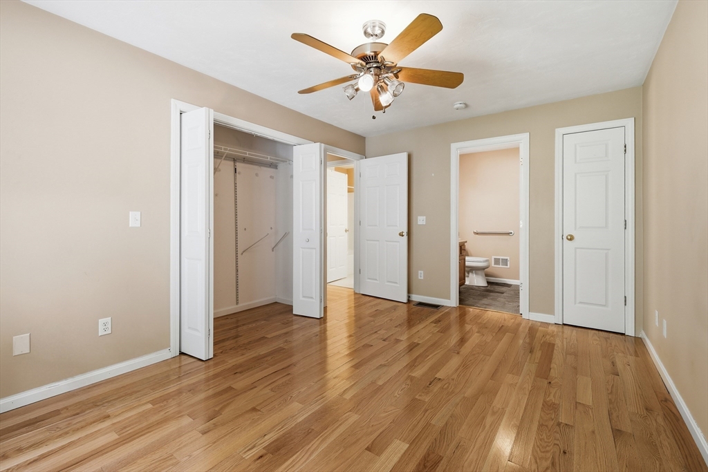 9 Rock Marsh Road, Unit B Wareham, MA 02571 - Photo 24 of 41 an empty room with wooden floor and a ceiling fan