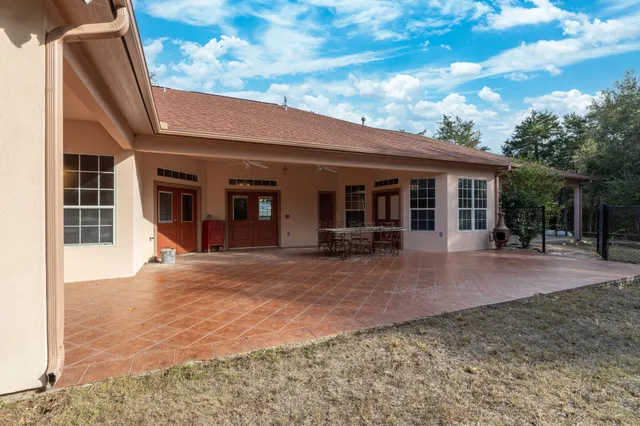a view of house with backyard and sitting area