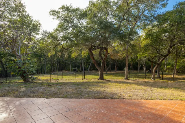 a front view of house with yard and trees in the background