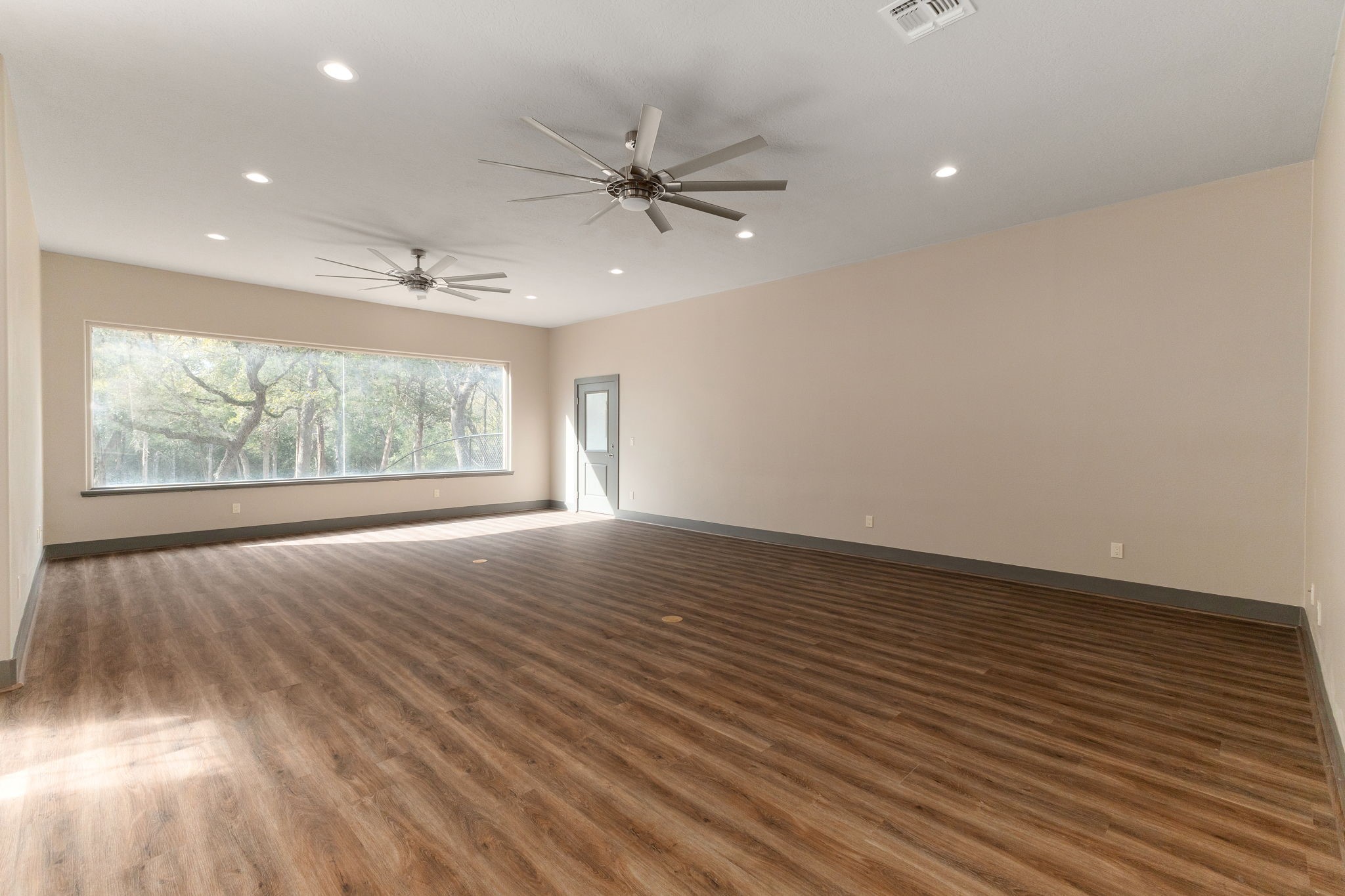 250 Bucek Lane Schulenburg, TX 78956 - Photo 5 of 45 an empty room with wooden floor fan and windows