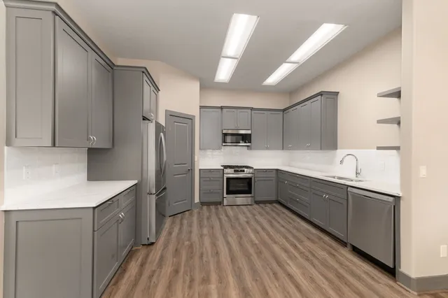 a kitchen with granite countertop a refrigerator stove and microwave
