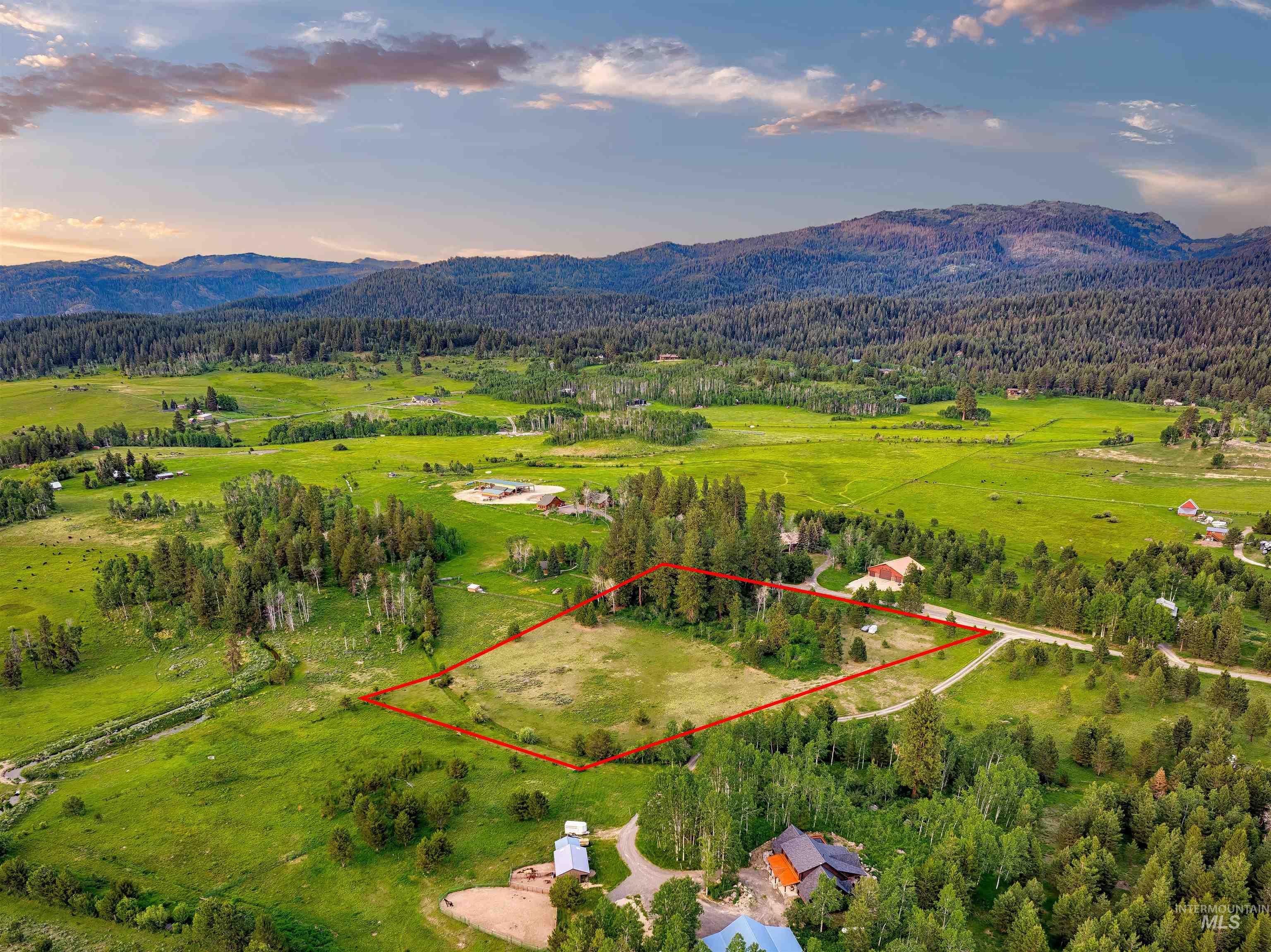 14055 Deerfield Road McCall, ID 83638 - Photo 2 of 19 Aerial view at dusk of property boundaries highlighted, a mountain view, a view of countryside, and a forest view