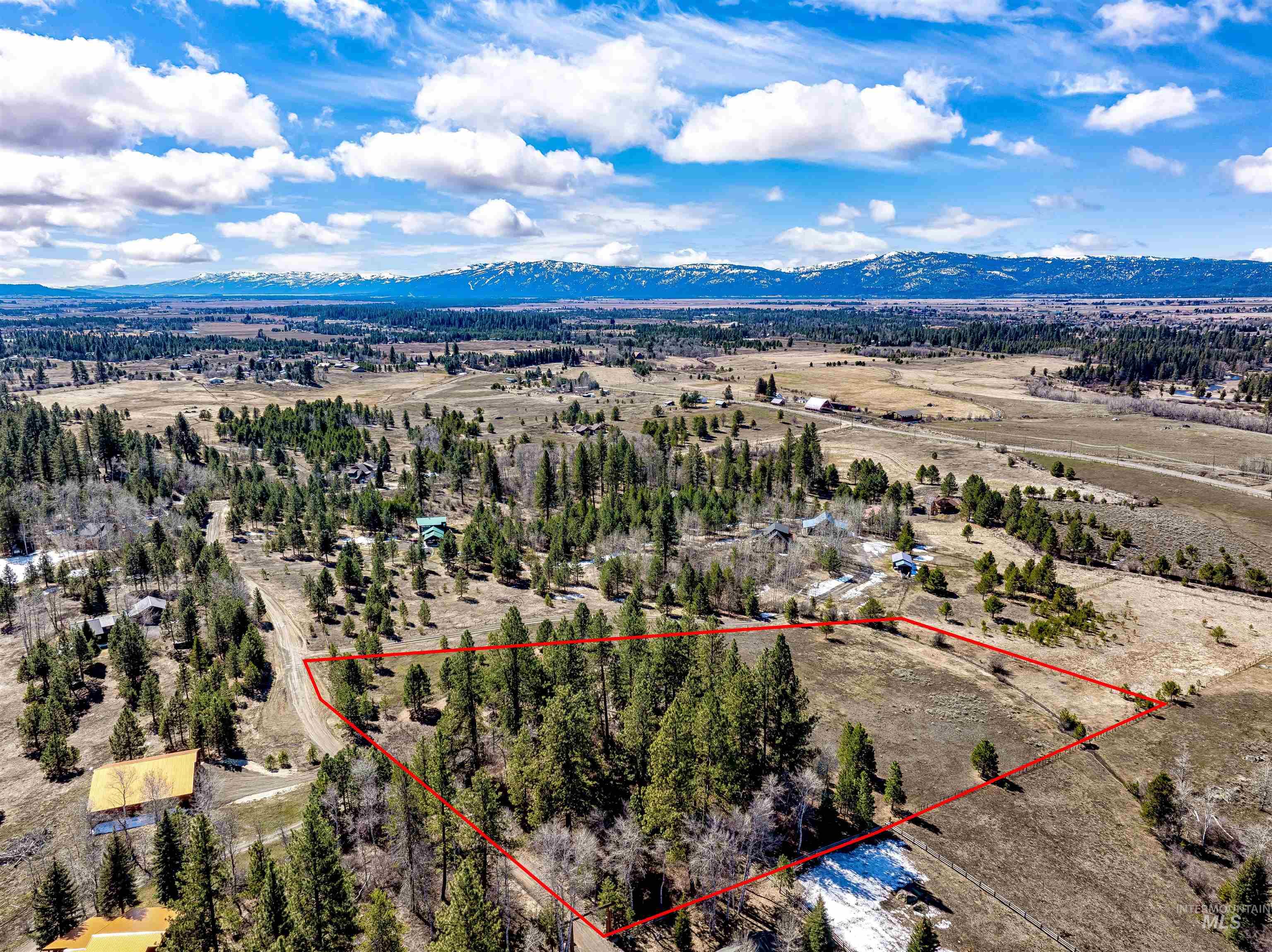 14055 Deerfield Road McCall, ID 83638 - Photo 9 of 19 Aerial view of sparsely populated area featuring a mountain backdrop and property parcel outlined