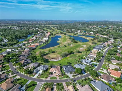 an aerial view of residential houses with outdoor space and trees