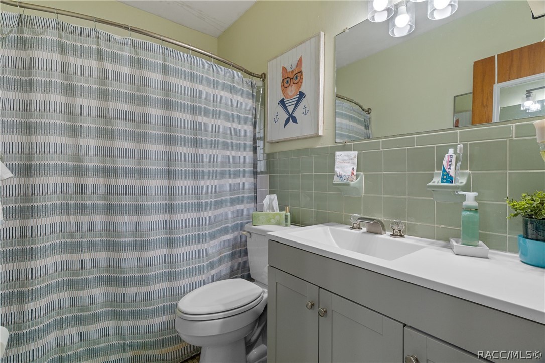 3355 South Highlands Avenue Inverness, FL 34452 - Photo 18 of 30 a bathroom with a sink a toilet and a mirror